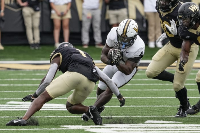 Sep 9, 2023; Winston-Salem, North Carolina, USA; Vanderbilt Commodores running back Patrick Smith (4) is tackled by Wake Forest Demon Deacons defensive back Caelen Carson (1) during the second half at Allegacy Federal Credit Union Stadium. Mandatory Credit: Jim Dedmon-USA TODAY Sports